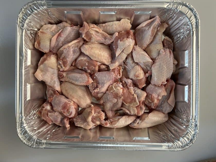 Chicken wings in a foil pan.