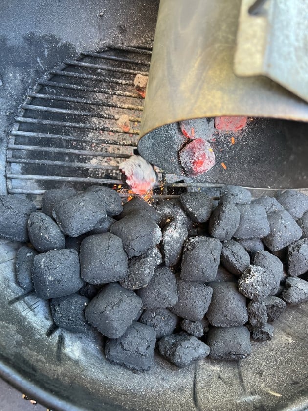Dumping lit coals on a pile of unlit ones for the Minion method.