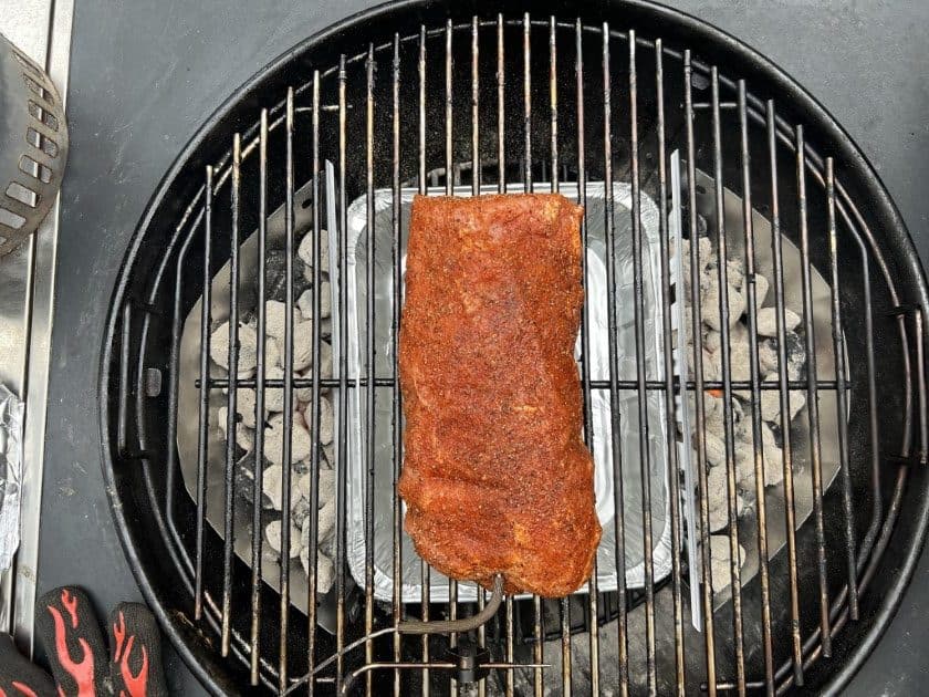 Pork loin placed in the center of the weber kettle over the drip pan.