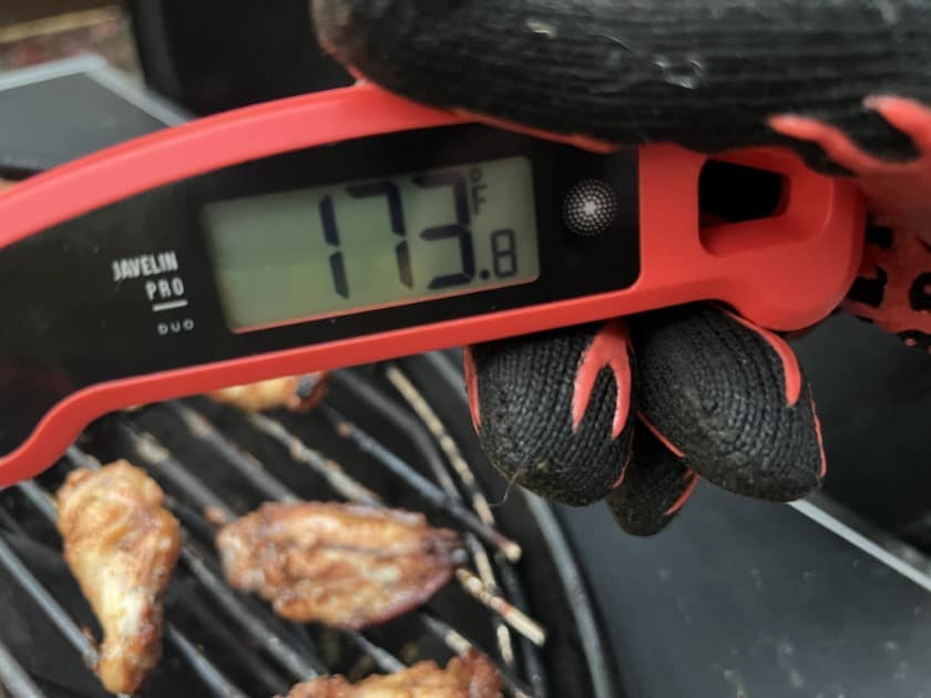 Temp probing chicken wings with the probe reading 173.8 degrees Fahrenheit 