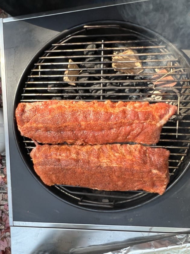 Two racks of ribs on a Weber Kettle grill.